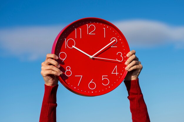 Hände halten Stillleben mit einer Wanduhr