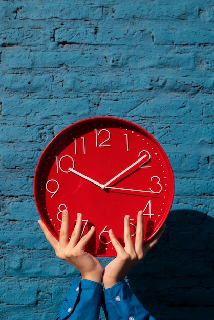 Hände halten Stillleben mit einer Wanduhr