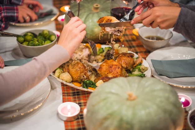 Hände mit Gabeln, die Fleisch nehmen