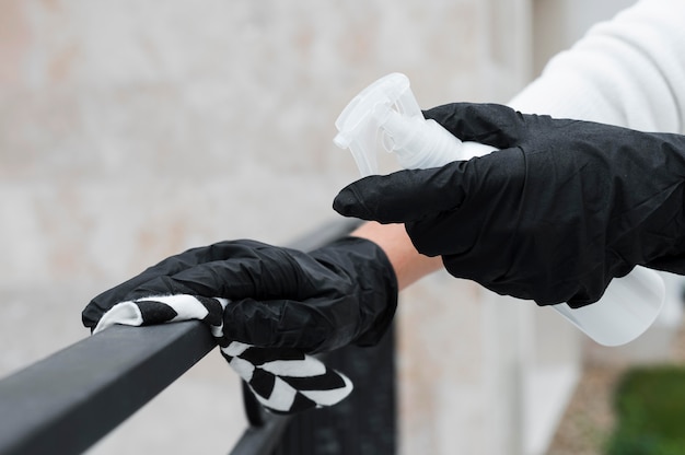 Kostenloses Foto hände mit handschuhen desinfizieren den handlauf