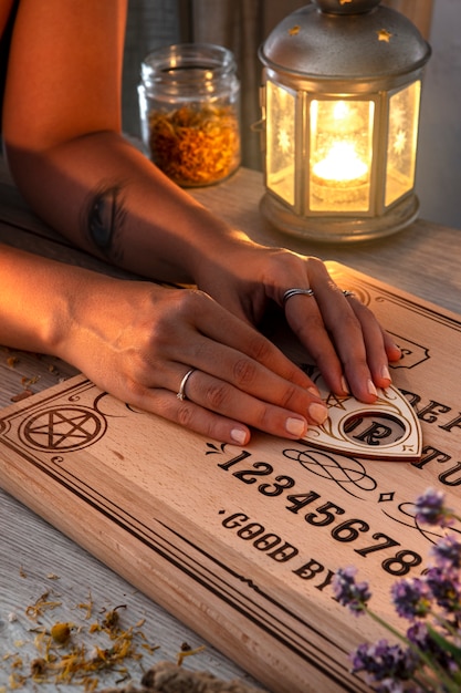 Kostenloses Foto hände mit hohem winkel des ouija-bretts