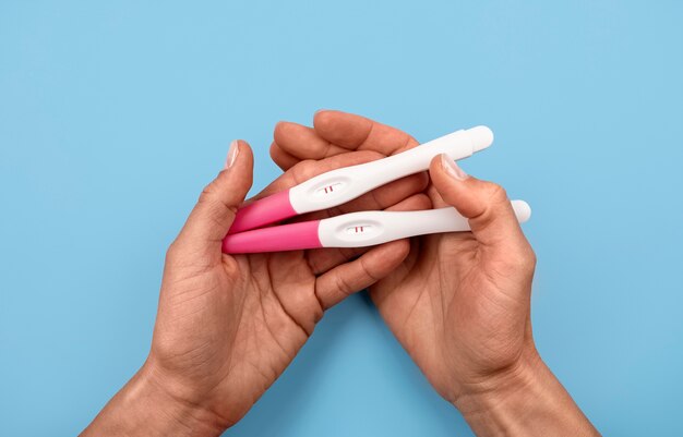 Hände mit positiven Schwangerschaftstests