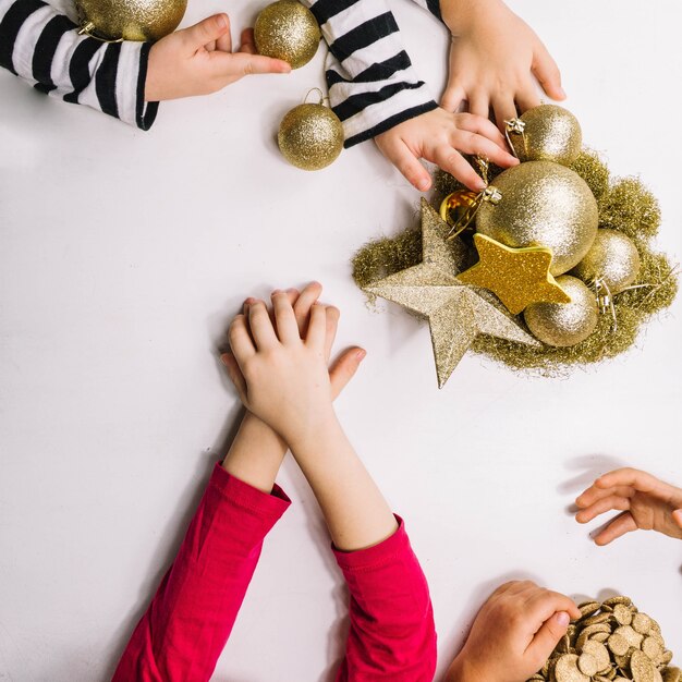 Hände und goldene Weihnachtsverzierungen