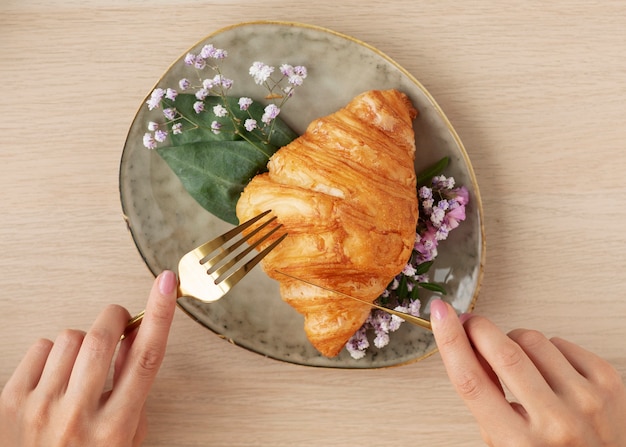 Hände von oben schneiden Croissants