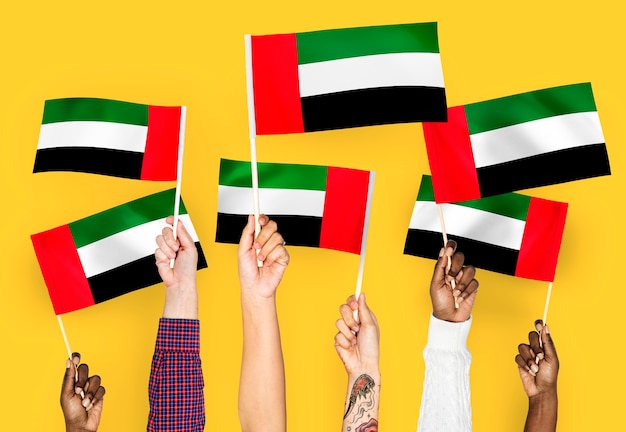 Kostenloses Foto hände wehende fahnen der vereinigten arabischen emirate