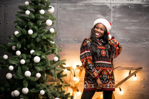 Hängende Spielwaren der afroen-amerikanisch Frau auf einem Weihnachtsbaum