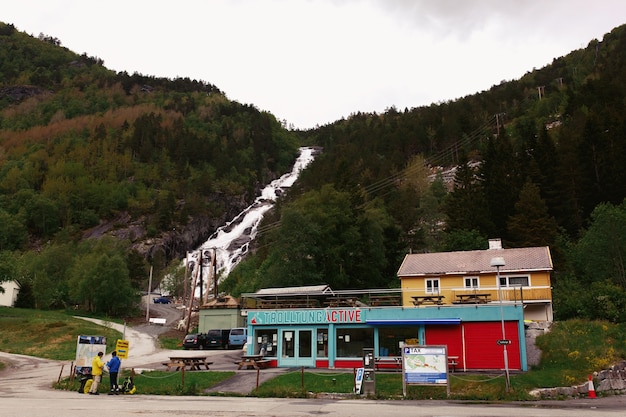 Häuser unter dem Felsen mit Wasserfall