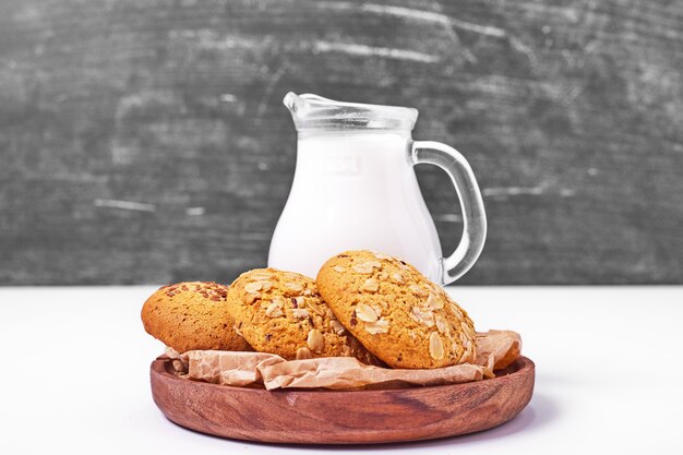 Haferflocken- und Sesamplätzchen mit Milch auf Weiß.