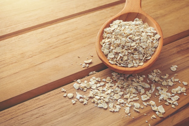 Haferflocken wird auf ein braunes Holz gelegt.