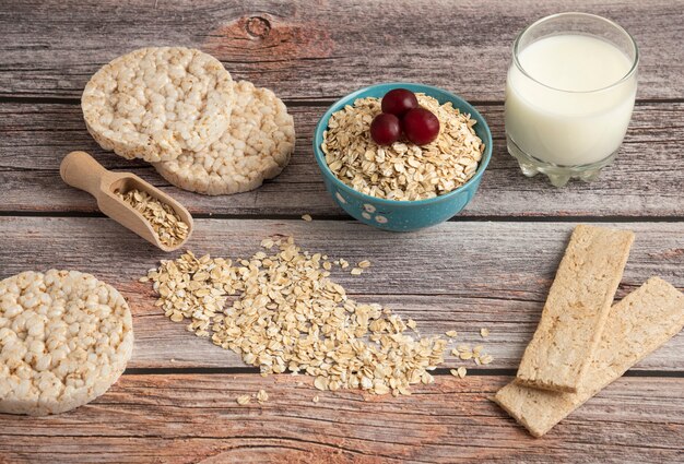 Haferflockencracker, Körner mit Beeren und eine Tasse Milch auf dem Tisch