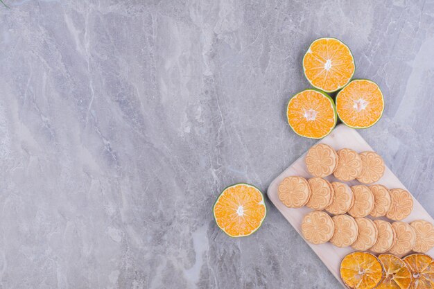 Haferkekse auf einer Holzplatte mit trockenen Orangenscheiben herum