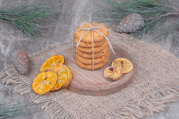 Haferkekse auf einer Holzplatte mit trockenen Orangenscheiben herum