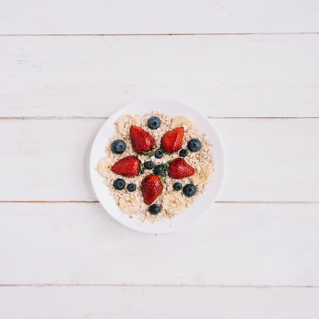 Hafermehl mit verschiedenen Beeren in der Schüssel auf Tabelle