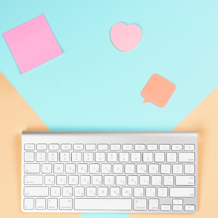 Kostenlose Foto haftnotizblock; herzform und sprechblase mit drahtloser weißer tastatur auf dualem hintergrund