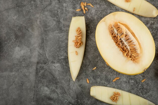 Halb geschnittene frische süße Melone auf Marmoroberfläche gelegt.