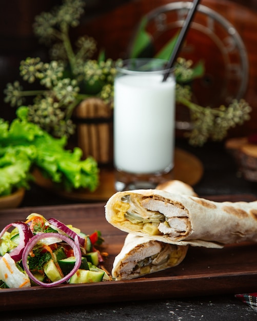 Halb geschnittenes Hühnchen-Döner, serviert mit Gemüsesalat