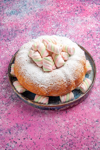 Halbe Draufsicht des Puderzuckerkuchens mit Marshmallows auf rosa Wand