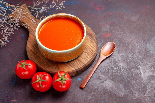 Halbe draufsicht leckere tomatensuppe mit frischen tomaten auf dunklem schreibtisch suppe tomatengericht mahlzeit sauce