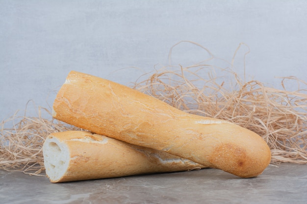 Halber Schnitt von französischem Baguette auf Marmoroberfläche