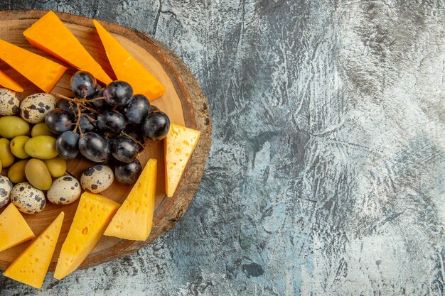 Halber Schuss köstlicher Snacks mit Obst und Speisen für Wein auf einem braunen Tablett auf grauem Hintergrund in horizontaler Ansicht