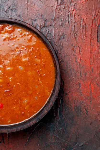 Halber Schuss Tomatensuppe in einer braunen Schüssel auf der linken Seite der gemischten Farbtabelle