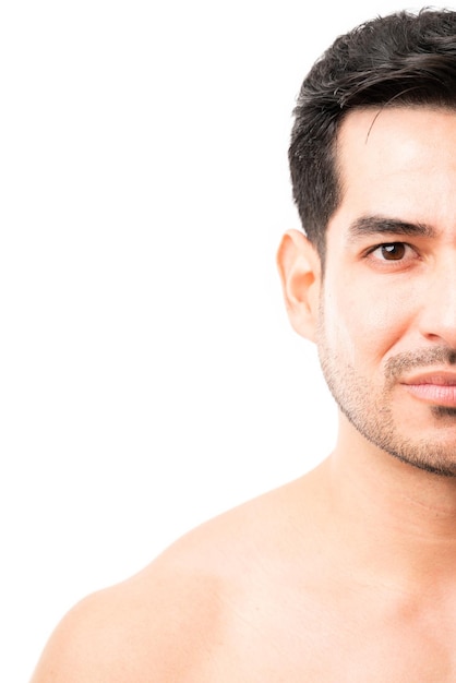 Halbes Gesicht eines jungen lateinamerikanischen männlichen Models mit Bart im Studio
