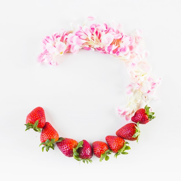 Halbkreis aus Blütenblättern und Erdbeeren