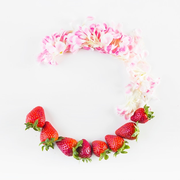 Halbkreis aus Blütenblättern und Erdbeeren