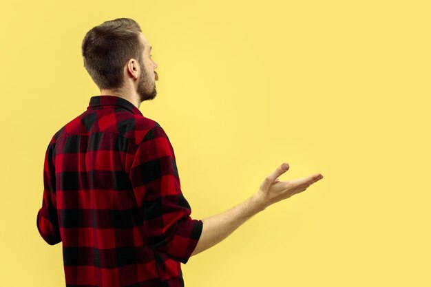 Halblanges Nahaufnahmeporträt des jungen Mannes im Hemd auf gelbem Raum. Die menschlichen Emotionen, Gesichtsausdruck Konzept. Vorderansicht. Trendige Farben. Negativer Raum