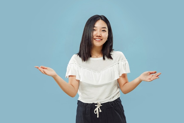 Halblanges Porträt der koreanischen jungen Frau auf Blau