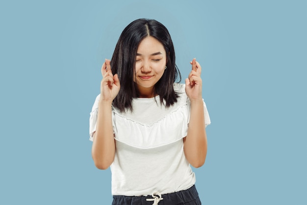 Halblanges Porträt der koreanischen jungen Frau. Weibliches Modell im weißen Hemd. Feiern wie ein Gewinner, sieht glücklich aus. Konzept menschlicher Emotionen, Gesichtsausdruck. Vorderansicht.