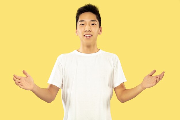 Halblanges Porträt des koreanischen jungen Mannes auf Gelb