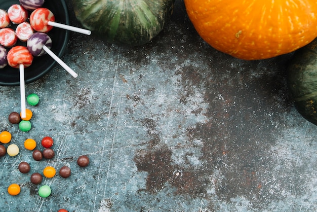 Kostenloses Foto halloween-bonbons, die auf seite mit den kürbisen liegen oben liegen