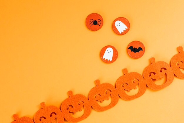 Halloween Dekoration mit Kürbisgirlande auf orangem Hintergrund