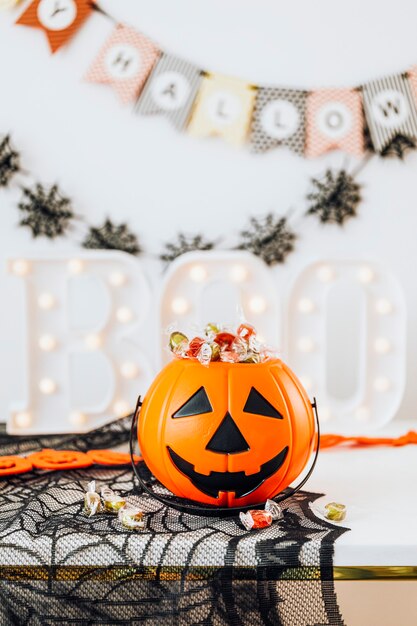 Halloween-Heimdekoration mit einem Kürbiskorb gefüllt mit Süßigkeiten