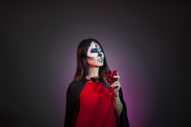 Kostenloses Foto halloween-konzept mit mädchen aus tasse trinken