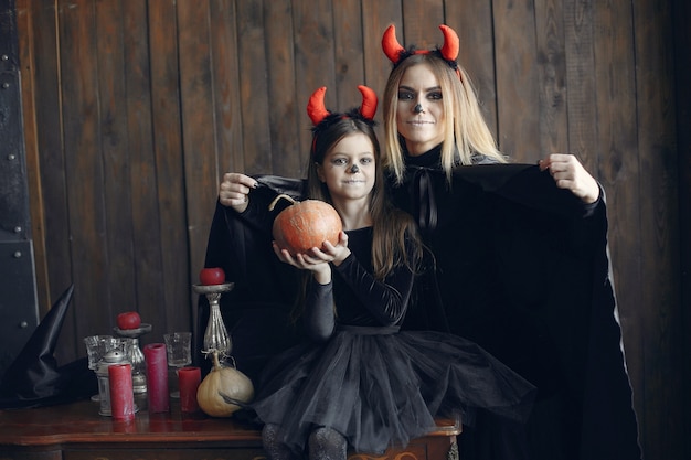 Halloween. Mutter und Tochter im Halloween-Kostüm. Familie zu Hause.