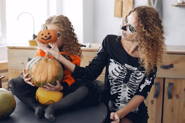 Halloween. Mutter und Tochter im Halloween-Kostüm im mexikanischen Stil. Familie zu Hause mit Kürbissen.