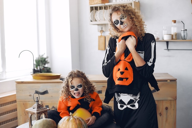 Halloween. Mutter und Tochter im Halloween-Kostüm im mexikanischen Stil. Familie zu Hause mit Kürbissen.
