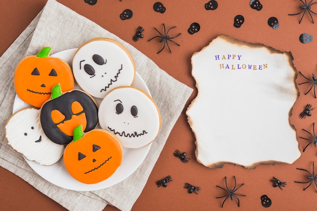 Kostenloses Foto halloween-pfefferkuchen auf brennender broschüre der platte nahe