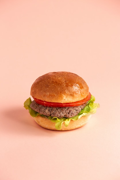 Hamburger mit Tomatensalatblatt und Rindfleischpastetchen in Burgerbrötchen