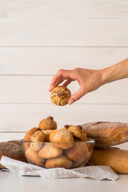 Kostenloses Foto hand brötchen aus der schüssel nehmen