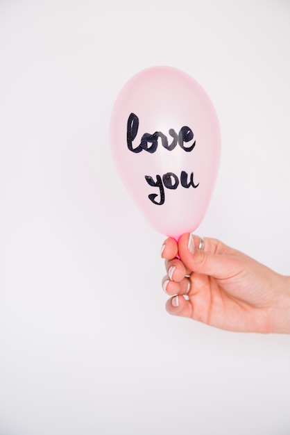 Hand der Frau mit Ballon mit Liebe Sie Aufschrift