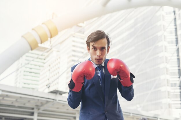 Hand des Geschäftsmannes, die Boxhandschuhe trägt.