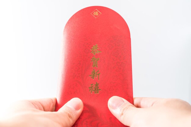 Hand des mannes, die mit chinesischem rotem umschlag (rotes paket) hält. chinesisches neujahrskonzept. (chinesisch 
