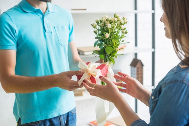 Hand des Mannes, die seiner Frau Geschenk gibt