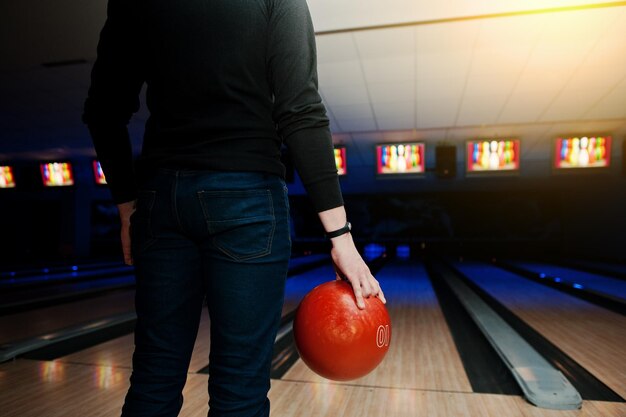 Hand des Mannspielers mit dem Armband, das Bowlingkugel hält