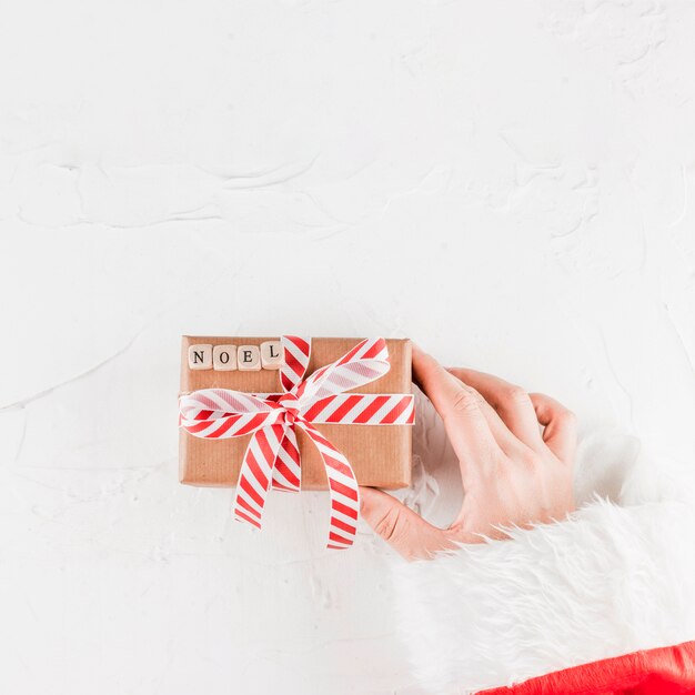 Hand, die anwesenden Kasten mit Noelaufschrift hält