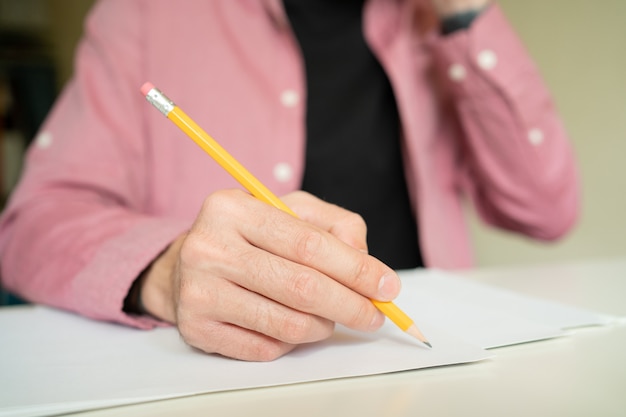 Hand, die Bleistift hält und auf Papier zeichnet