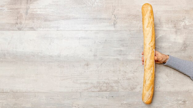 Hand, die einen Brotstab mit Kopienraum hält